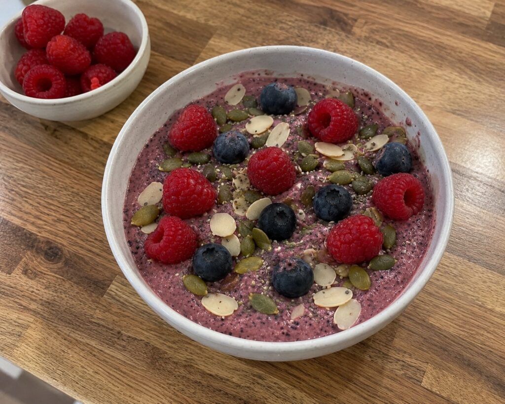 Berry Smoothie Bowl topped with raspberries, blueberries, pumpkin seeds and almonds