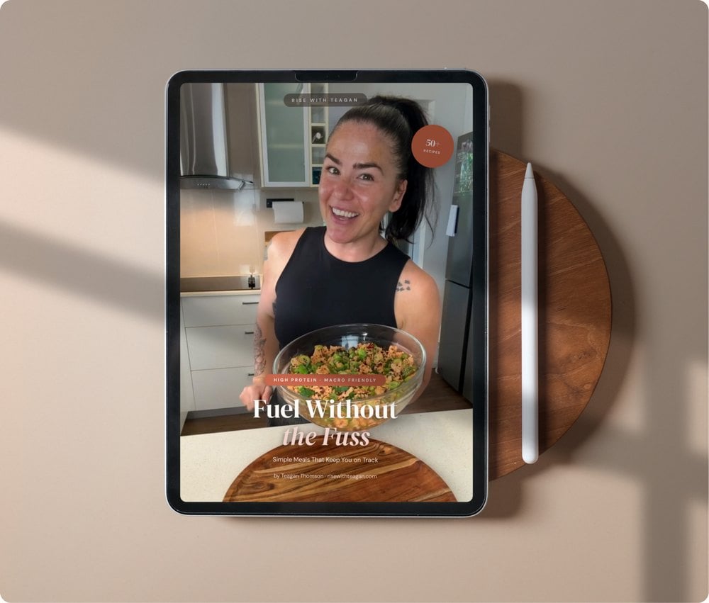 The Fuel Without the Fuss recipe book open on a tablet beside a wooden board