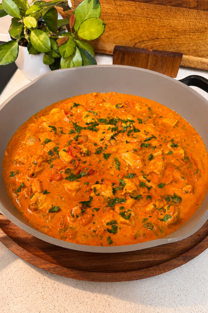 Creamy Paprika Chicken in a pan, topped with chopped parsley